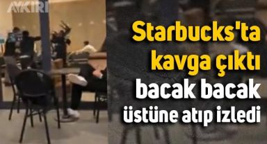 Starbucks'ta masa ve sandalyeler havada uçuştu, bacak bacak üstüne atıp izledi