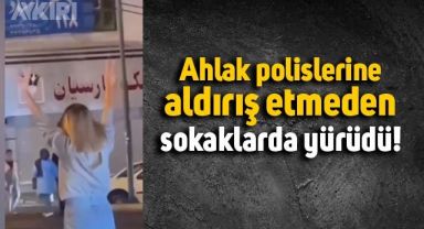 İran'da ahlak polislerine meydan okuyarak sokaklarda yürüyen kız