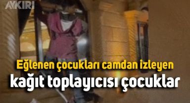 Eğlenen çocukları camdan izleyen kağıt toplayıcısı çocuklar